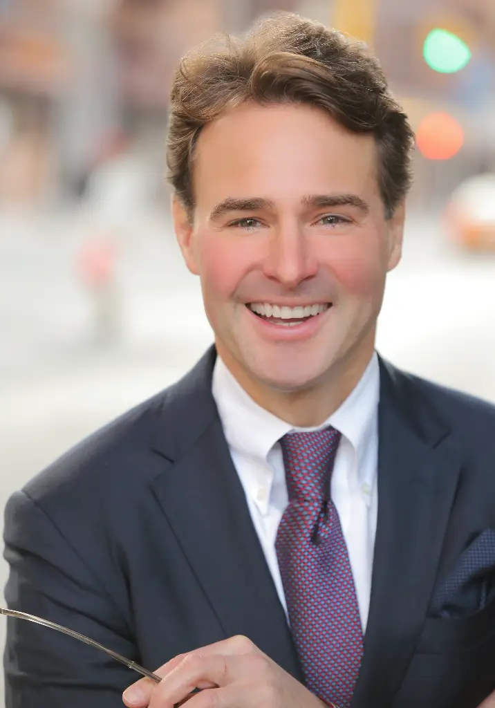 A man in suit and tie smiling for the camera.